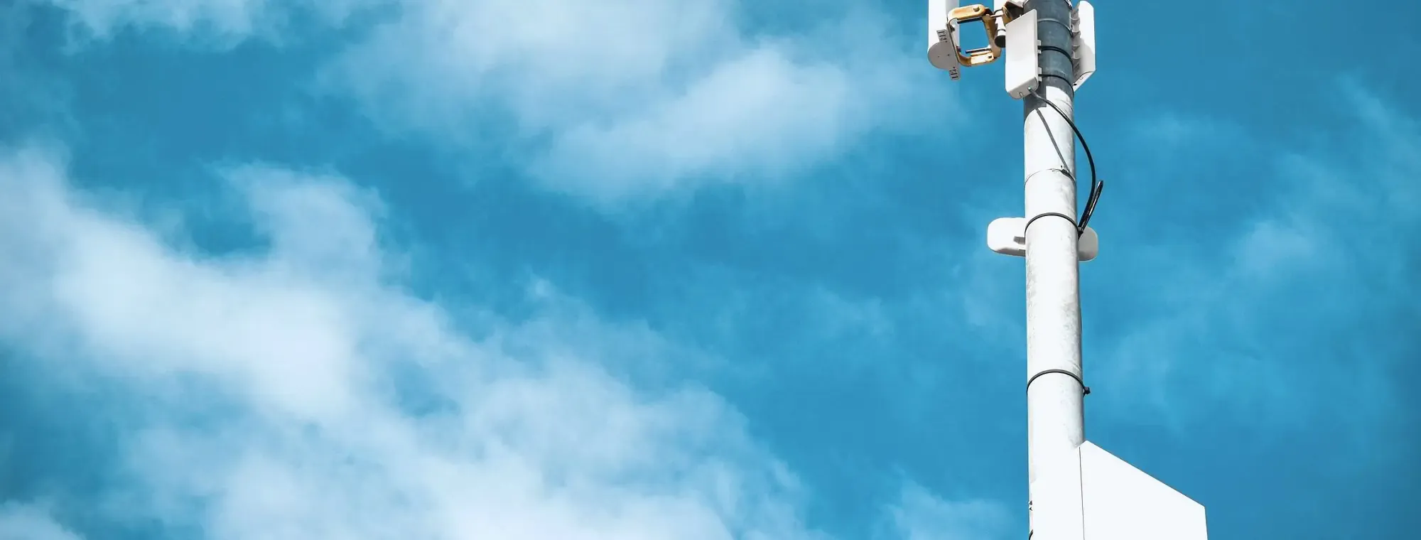 Cámara de videovigilancia sobre un poste, recortada contra el cielo